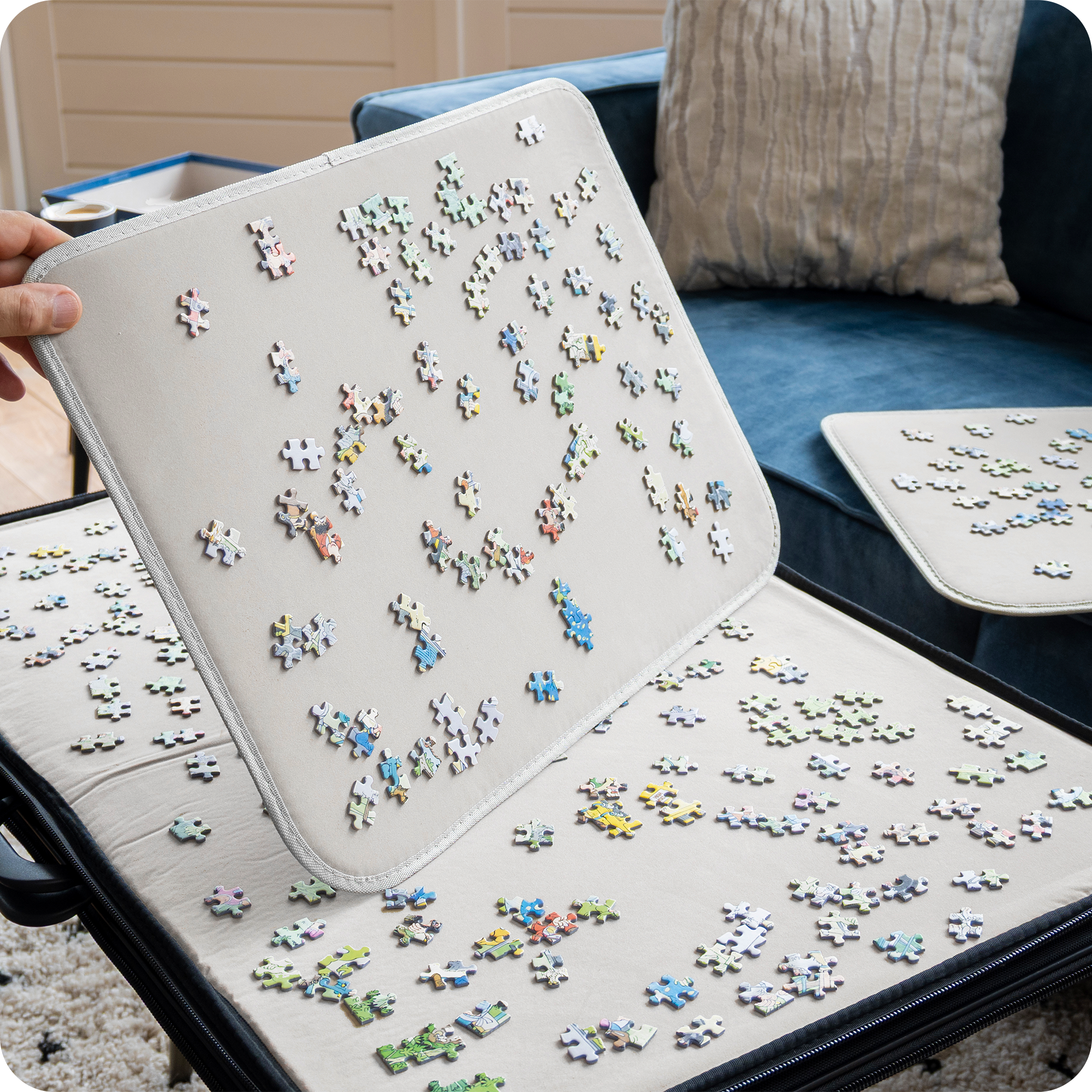 Een zwarte puzzelmap met een witte binnenkant. Het bijgeleverde paneel wordt schuin gehouden met puzzelstukjes erop om te laten zien dat de puzzelmap antislip is.
